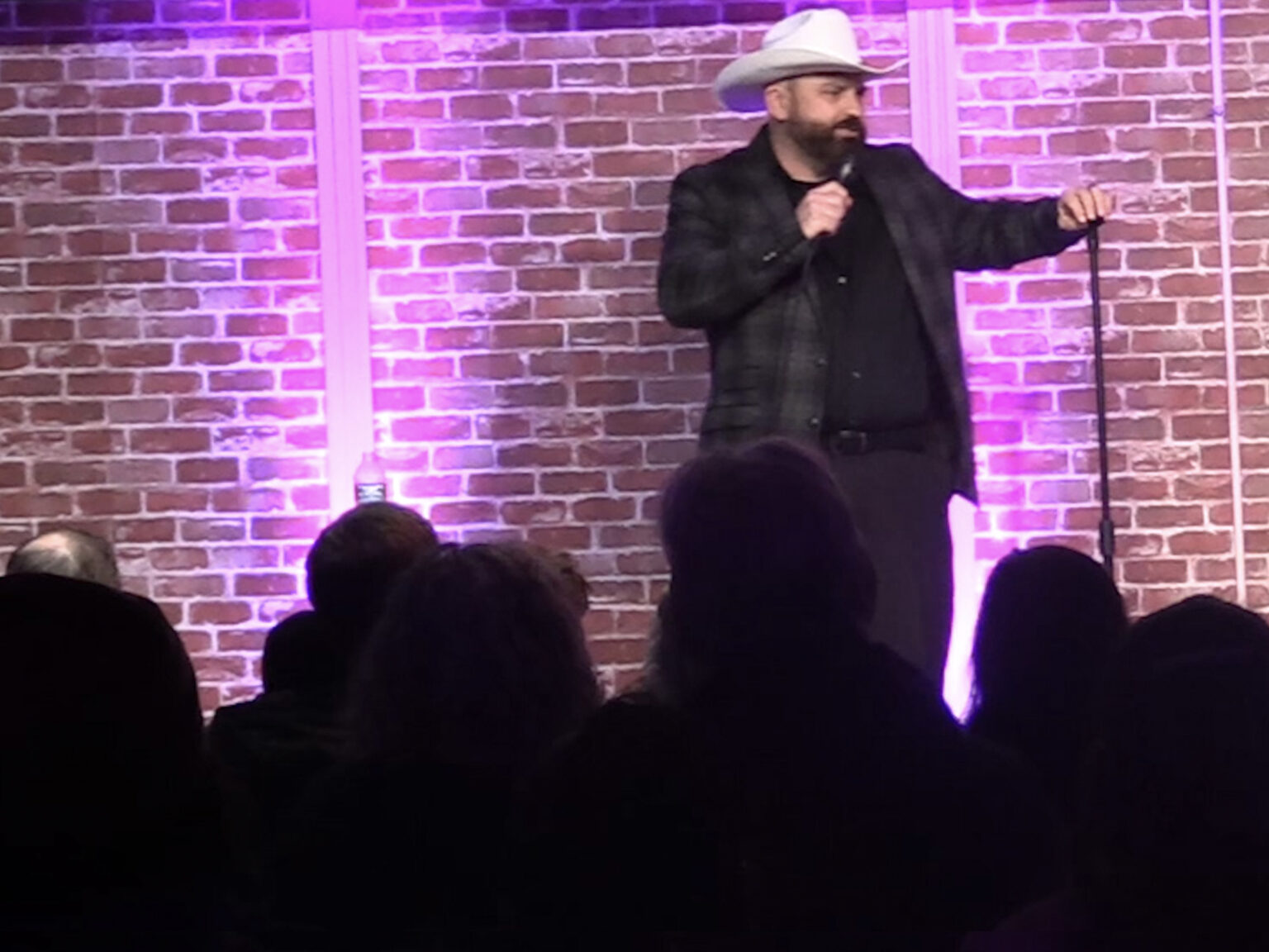 Tim Palmer in a cowboy hat against a brick wall